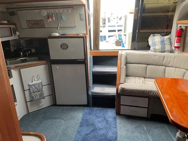 Slide: The Image of Interior of 1989 Sea Ray 390 Express Cruiser with kitchenette and seating area. - 33