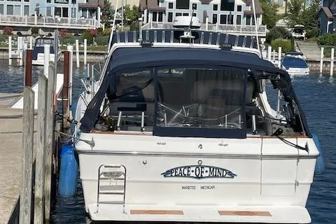 Slide: The Image of 1989 Sea Ray 390 Express Cruiser docked at a marina with waterfront homes in the background. - 4