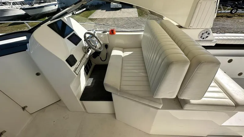 Slide: The Image of 2009 Eliminator 47' Cat boat interior with white leather seating and steering console. - 7