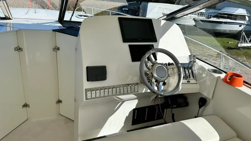 Slide: The Image of 2009 Eliminator 47' Cat boat helm with steering wheel and control panel. - 8
