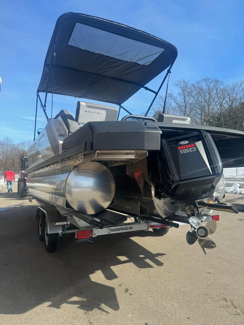 Slide: The Image of 2024 Manitou Cruise 22 Max Bench pontoon boat with canopy and outboard motor. - 3