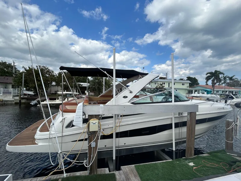 Slide: The Image of 2014 Sea Ray 370 Venture docked at a marina under a partly cloudy sky. - 12