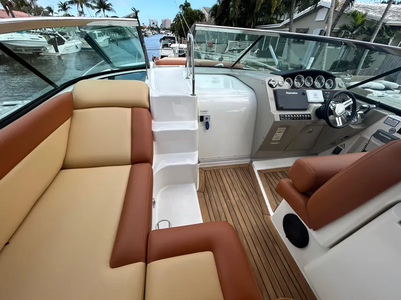 Slide: The Image of 2014 Sea Ray 370 Venture boat interior with tan and brown seating, helm, and wooden flooring. - 14