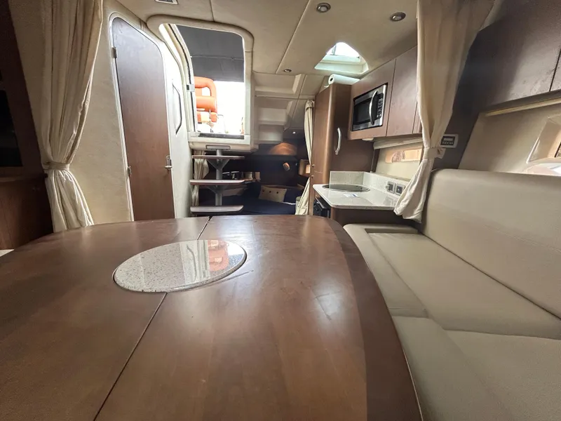 Slide: The Image of 2014 Sea Ray 370 Venture interior with dining area, kitchenette, and seating. - 17