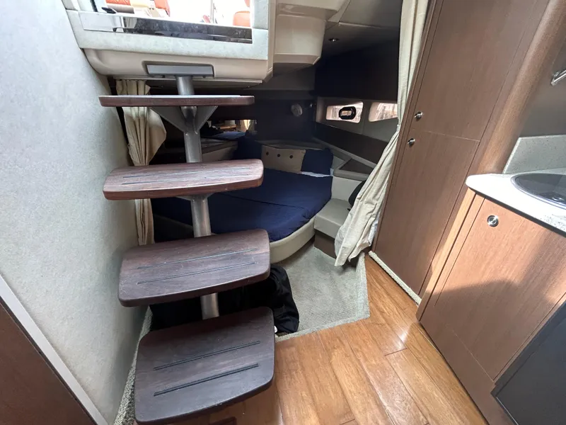 Slide: The Image of Interior cabin of 2014 Sea Ray 370 Venture with wooden stairs and cozy sleeping area. - 21