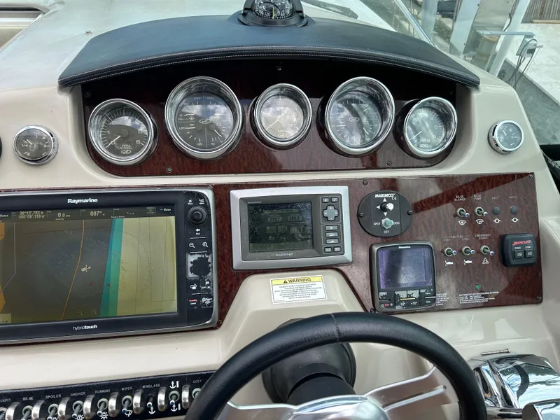 Slide: The Image of 2014 Sea Ray 370 Venture dashboard with navigation and control instruments. - 25