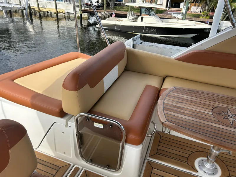 Slide: The Image of 2014 Sea Ray 370 Venture boat with tan and brown seating and wooden table. - 37
