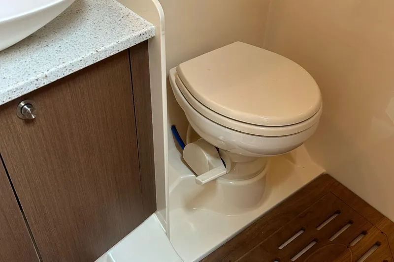 Slide: The Image of 2014 Sea Ray 370 Venture bathroom with toilet and wooden cabinet. - 46