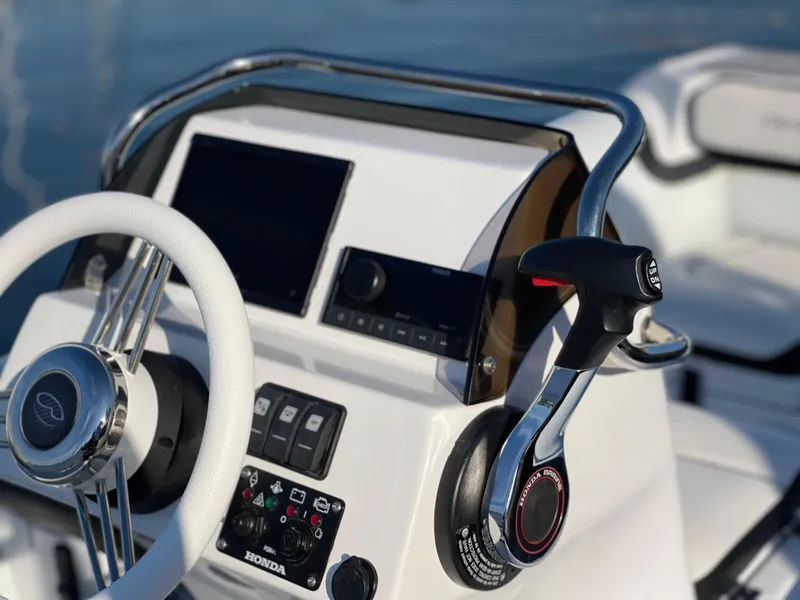 Slide: The Image of 2024 Walker Bay Generation 13 LTE boat dashboard with steering wheel and control panel. - 5