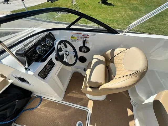 Slide: The Image of 2023 Bayliner DX 2050 boat interior with steering wheel and beige captain's chair. - 14