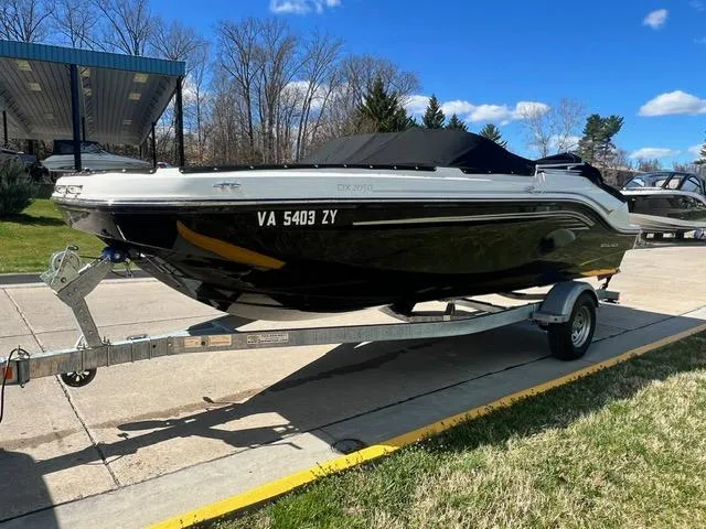 Slide: The Image of 2023 Bayliner DX 2050 boat on a trailer, parked outdoors. - 3