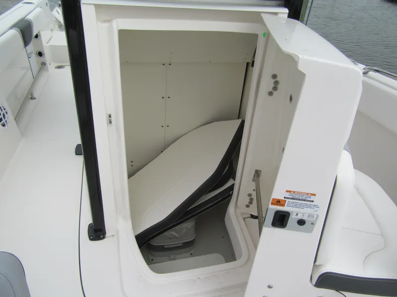 Slide: The Image of 2024 Robalo R230 Center Console boat storage compartment with open door. - 10