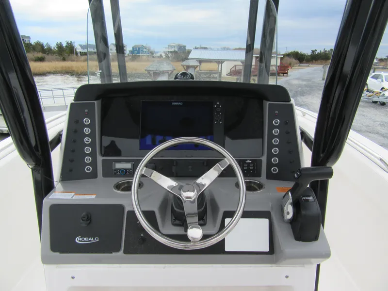 Slide: The Image of 2024 Robalo R230 Center Console boat dashboard with steering wheel and controls. - 6