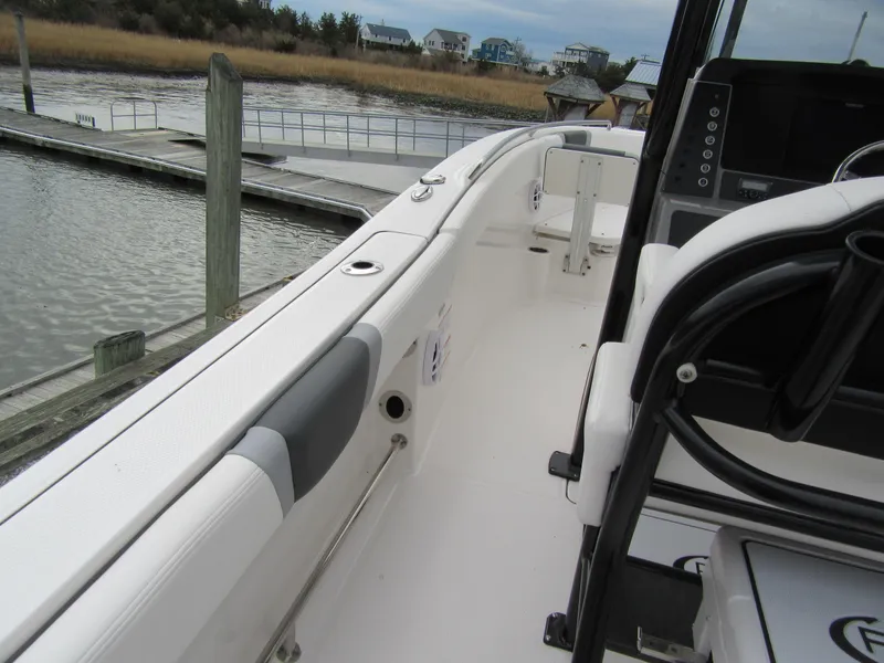 Slide: The Image of 2024 Robalo R230 Center Console boat docked by a serene waterfront. - 8