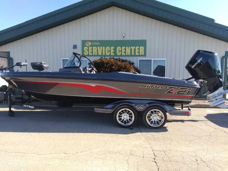 The Image of 2024 Nitro ZV21 boat at service center, sleek design, dual-axle trailer. - 0