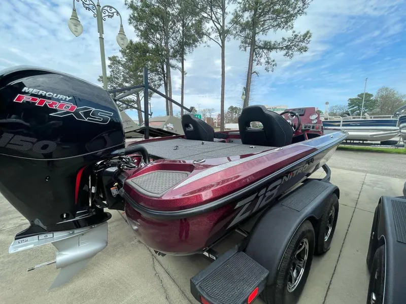 Slide: The Image of 2024 Nitro Z18 bass boat with Mercury Pro XS 150 engine, parked on trailer. - 2
