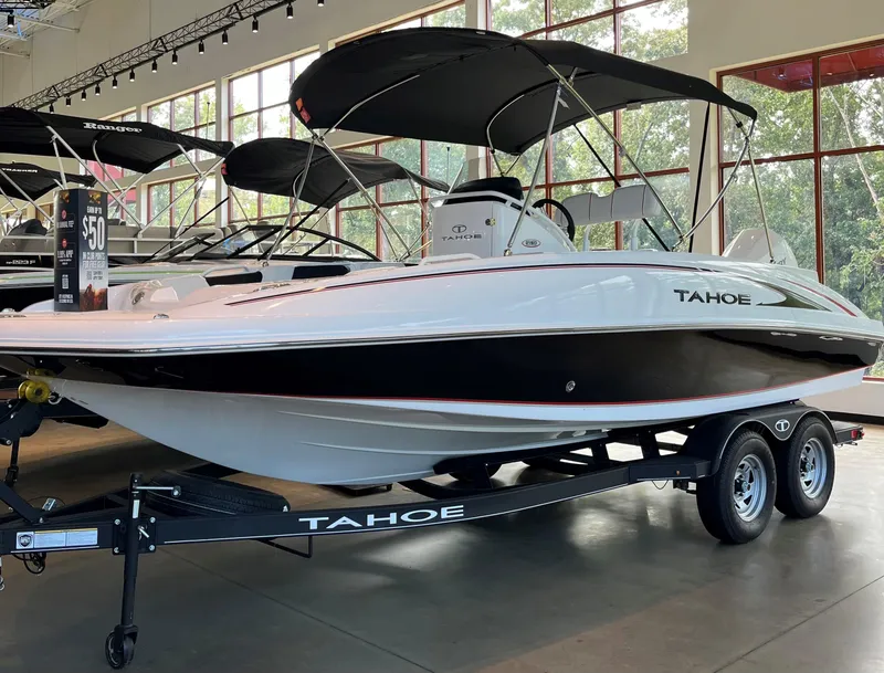 The Image of 2024 Tahoe 2150 CC boat on display in showroom with trailer. - 0