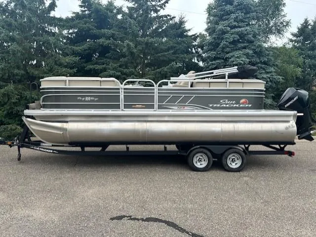 Slide: The Image of 2023 Sun Tracker Party Barge 22 XP3 pontoon boat on trailer, parked outdoors. - 6