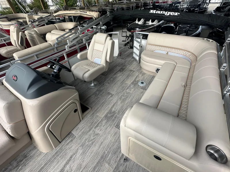 Slide: The Image of 2024 Ranger Reata 220C boat interior with beige seating and wood-style flooring. - 12