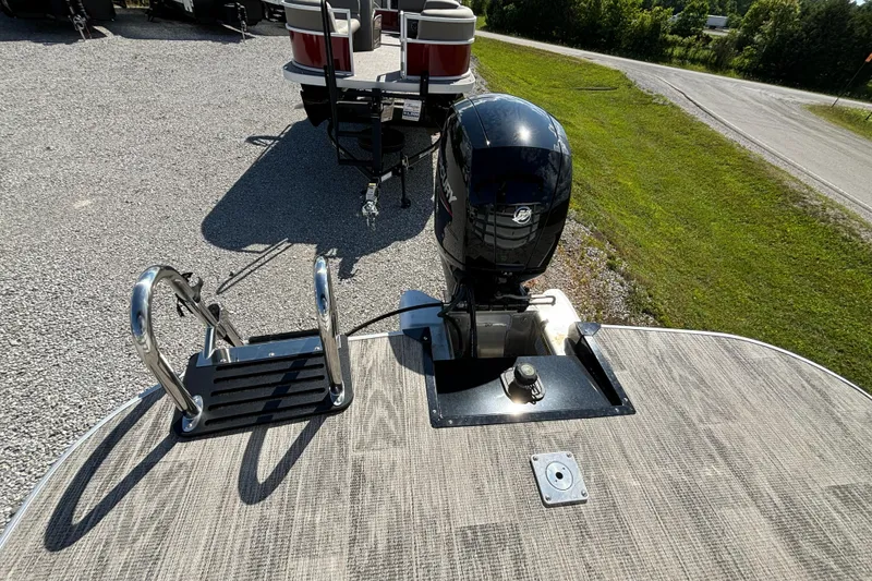 Slide: The Image of 2024 Ranger Reata 220C boat with outboard motor and swim ladder on a sunny day. - 26