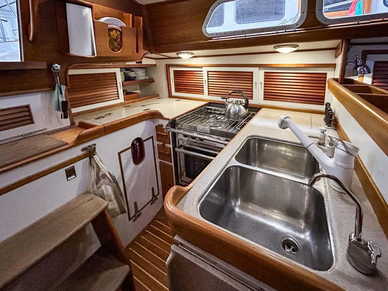 Slide: The Image of Hinckley Sou'wester 42 MKII 1996 yacht kitchen with stove, sink, and wooden cabinetry. - 16
