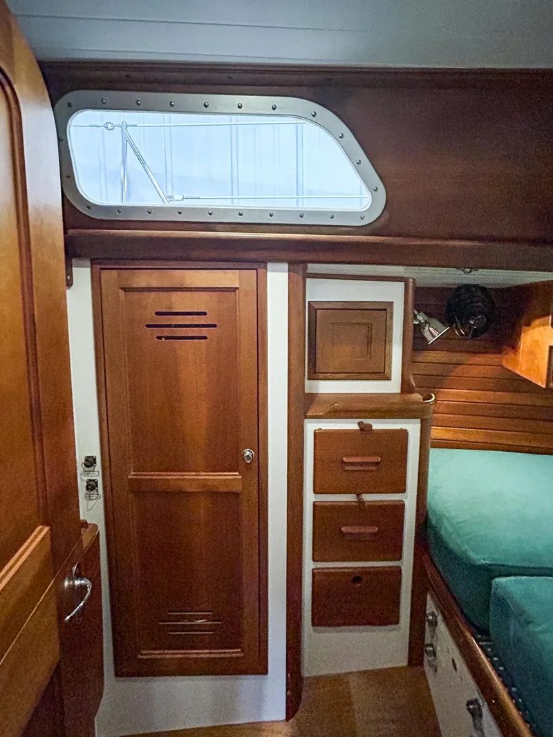Slide: The Image of Interior of 1996 Hinckley Sou'wester 42 MKII with teal seating and wooden table. - 30