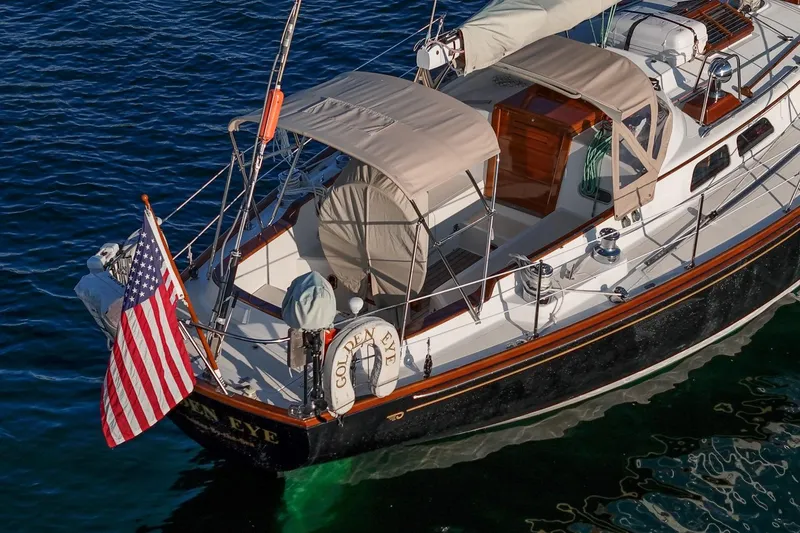 Slide: The Image of 1996 Hinckley Sou'wester 42 MKII sailboat with American flag on calm water. - 58