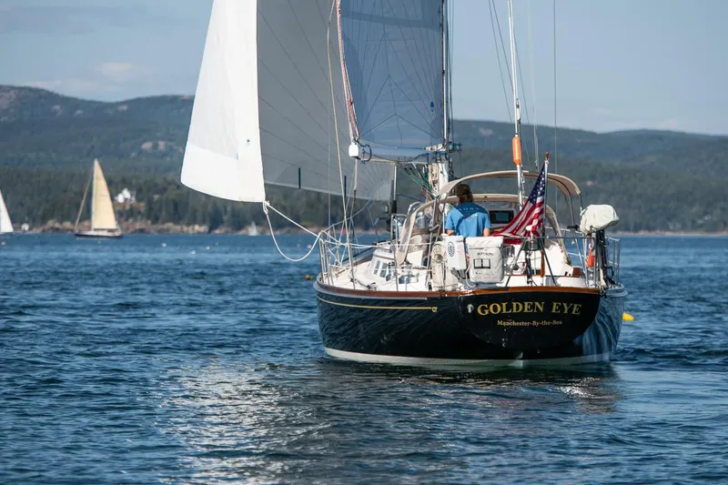 Slide: The Image of Hinckley Sou'wester 42 MKII sailboat, 1996, named "Golden Eye," sailing on a scenic lake. - 59