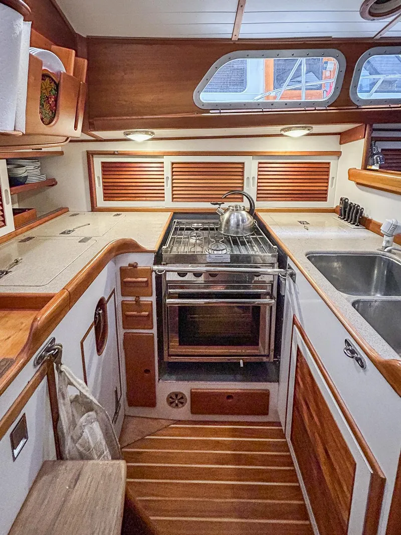 Slide: The Image of Hinckley Sou'wester 42 MKII 1996 yacht interior with wooden cabinetry and compact kitchen. - 15