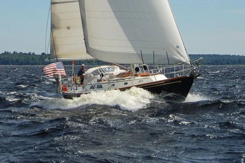 Slide: The Image of Hinckley Sou'wester 42 MKII sailboat anchored in a serene rocky cove, 1996 model. - 2