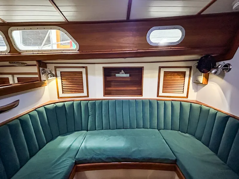 Slide: The Image of Interior of 1996 Hinckley Sou'wester 42 MKII with teal seating and wooden accents. - 24