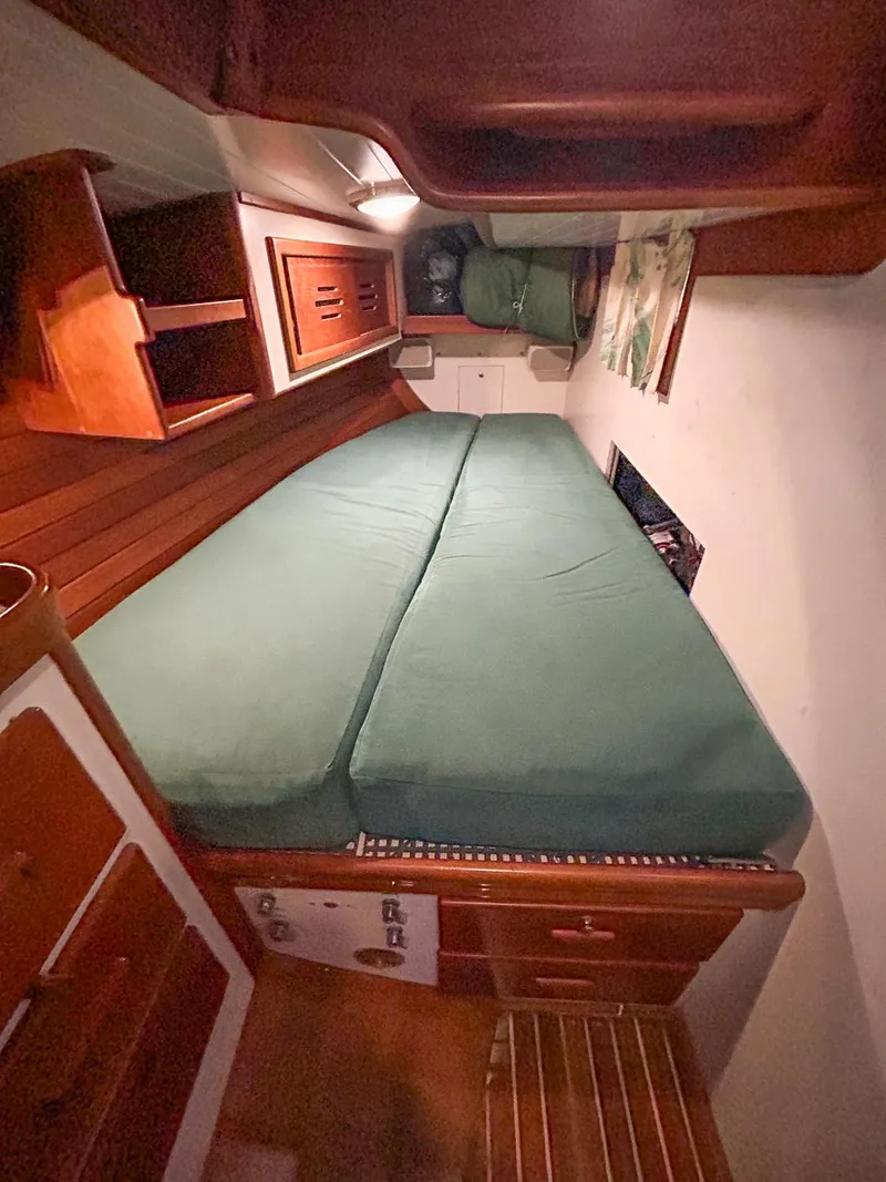 Slide: The Image of Interior of 1996 Hinckley Sou'wester 42 MKII with teal cushioned seating and wooden accents. - 28