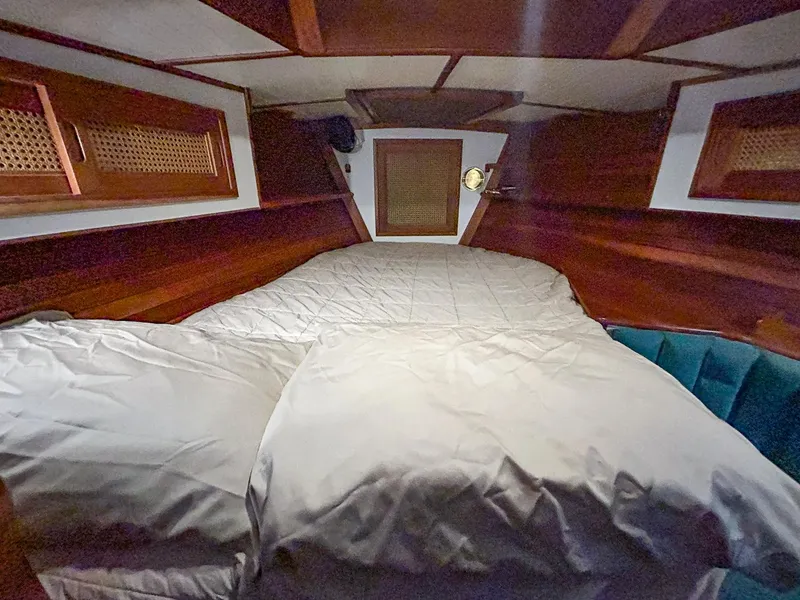 Slide: The Image of Hinckley Sou'wester 42 MKII 1996 cabin interior with green bedding and wooden cabinetry. - 33