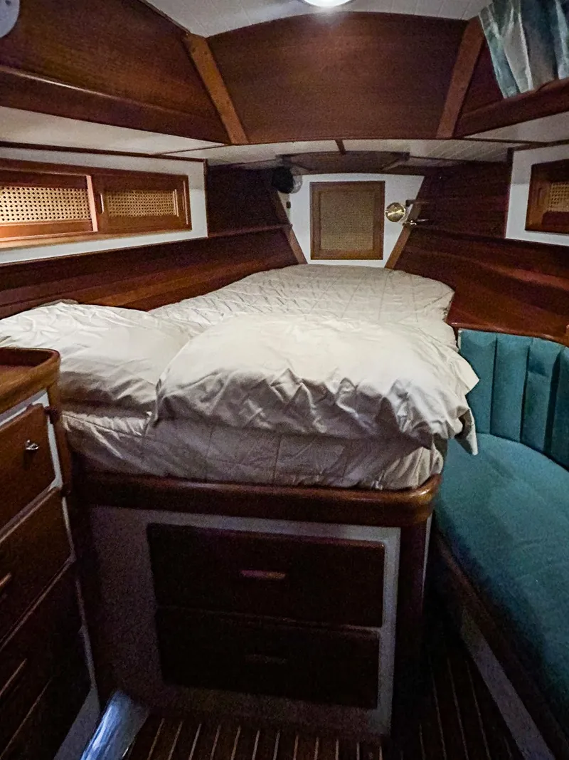 Slide: The Image of Interior of 1996 Hinckley Sou'wester 42 MKII with wooden cabinetry and teal bedding. - 34