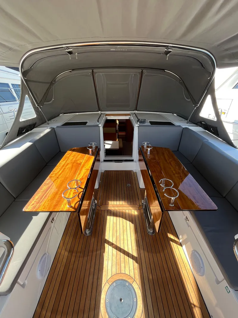 Slide: The Image of Luxurious 2021 Bavaria C45 yacht interior with wooden tables and cushioned seating. - 28