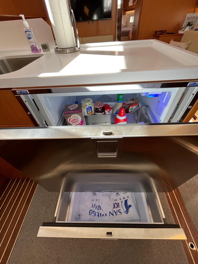 Slide: The Image of Modern Bavaria C45 2021 yacht kitchen with open fridge and freezer. - 34