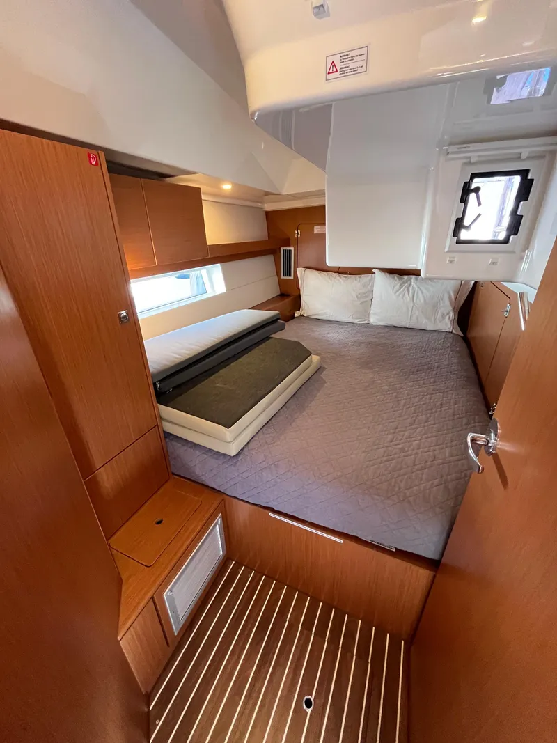 Slide: The Image of Interior cabin of 2021 Bavaria C45 yacht with wooden finishes and a cozy bed. - 44