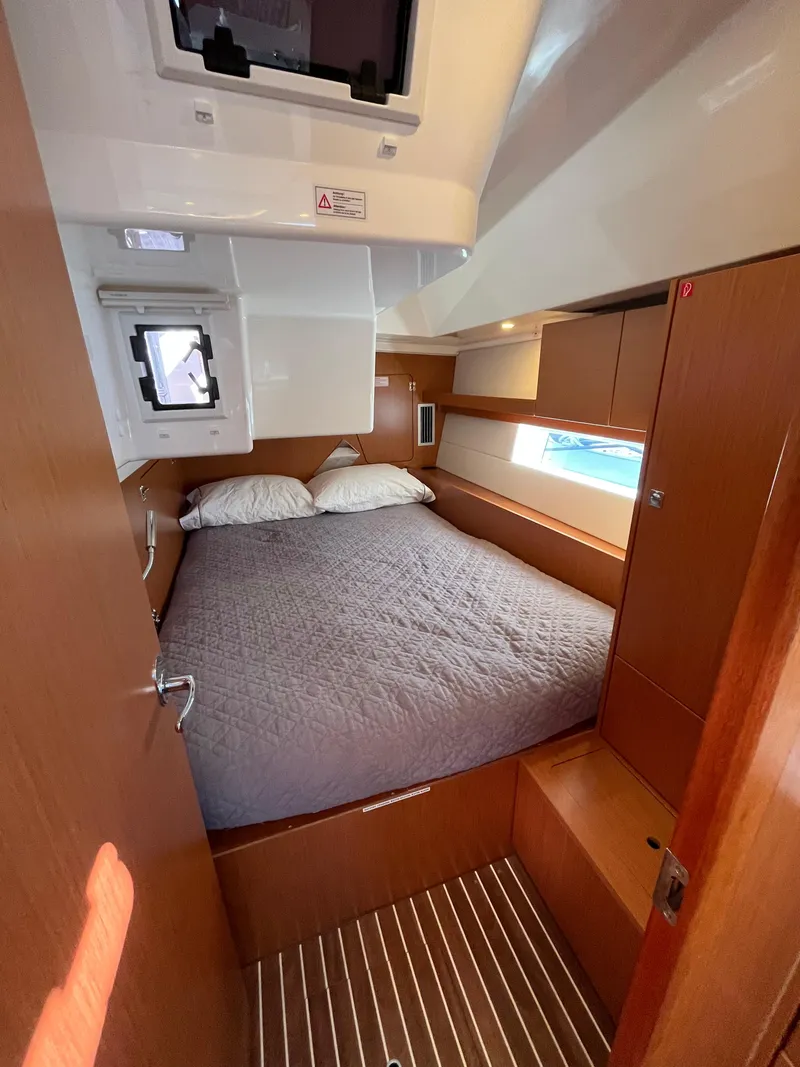 Slide: The Image of 2021 Bavaria C45 yacht cabin with double bed and wooden interior. - 45