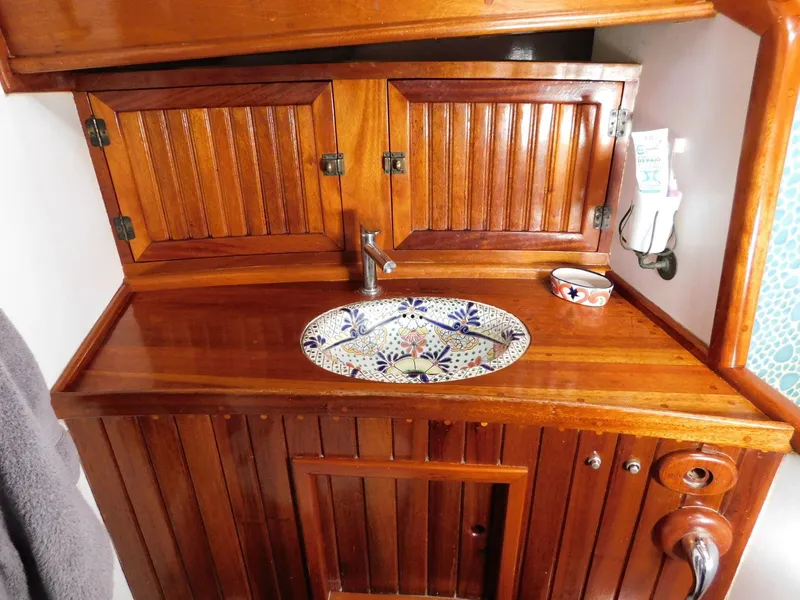 Slide: The Image of Wooden bathroom vanity with decorative sink on 1964 Custom 65 Pilothouse Schooner. - 9
