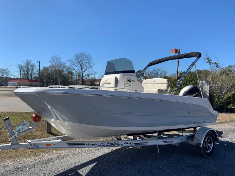 Slide: The Image of 2024 Stingray 173 CC boat on trailer, side view, outdoors. - 1