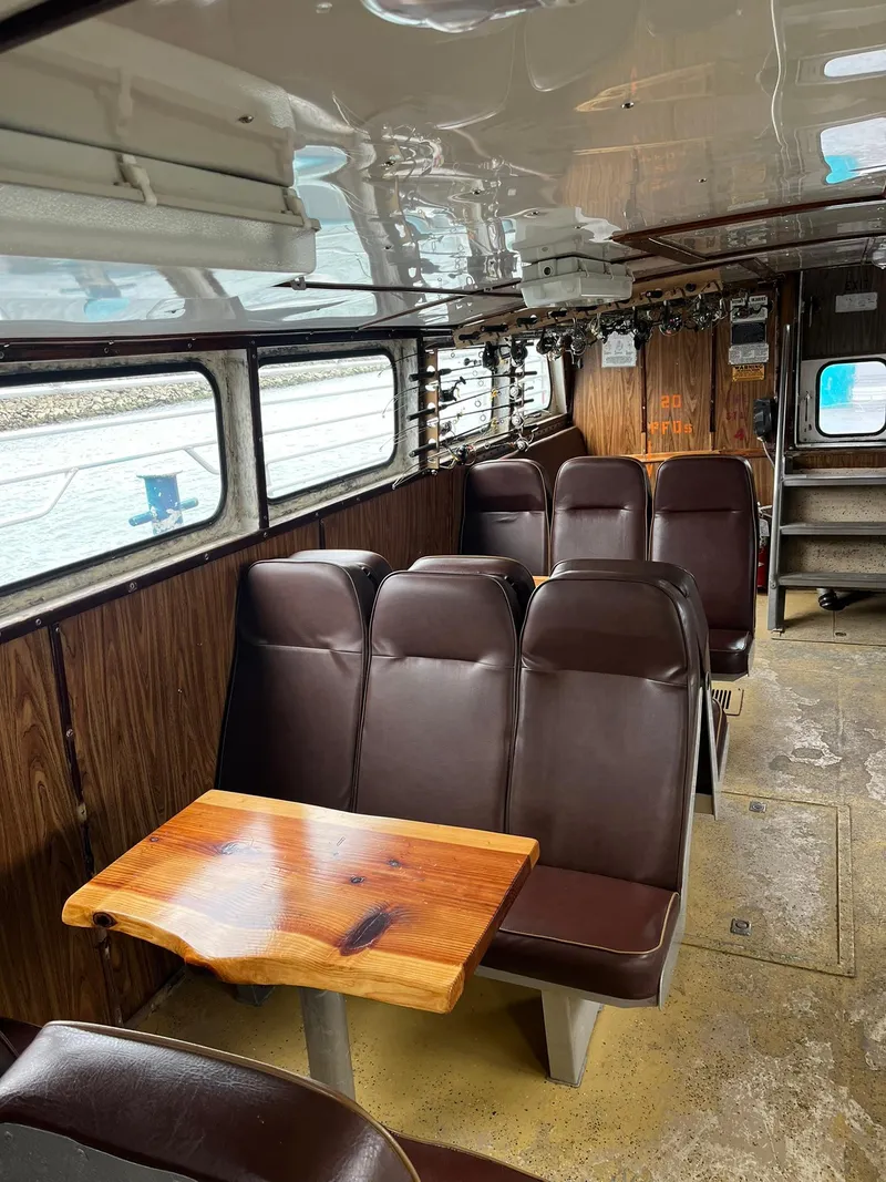 Slide: The Image of Interior of 1983 Swiftships Charter Boat with brown seating and wooden table. - 16