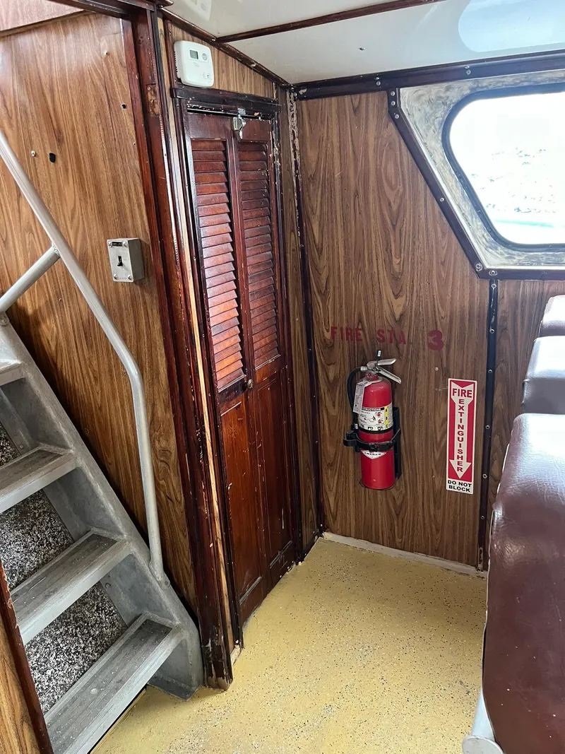 Slide: The Image of Interior of 1983 Swiftships Charter Boat with wood paneling and safety equipment. - 22