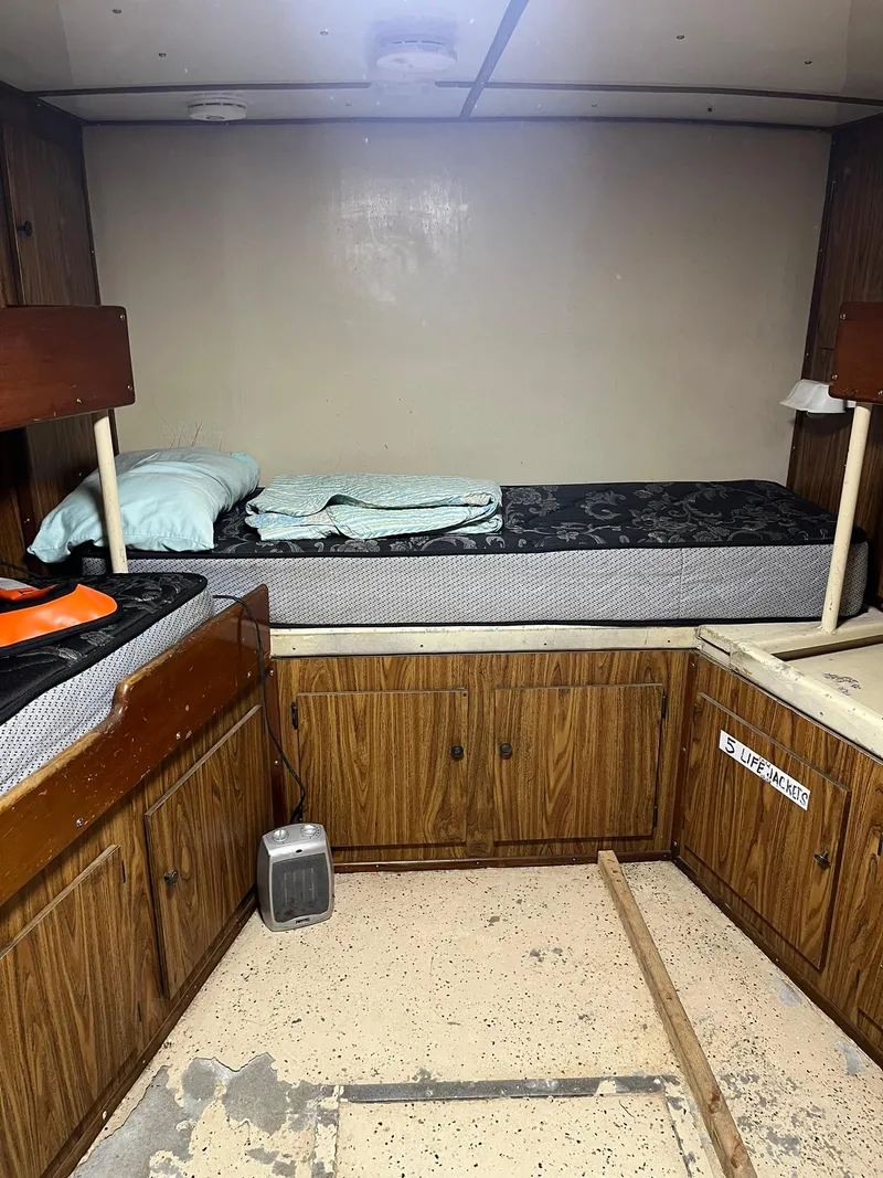 Slide: The Image of Interior of 1983 Swiftships Charter Boat with wooden cabinets and a single bed. - 23