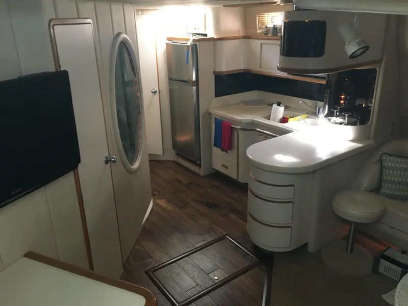 Slide: The Image of Interior of 1994 Sea Ray 500 Sundancer yacht with modern kitchen and wood flooring. - 12