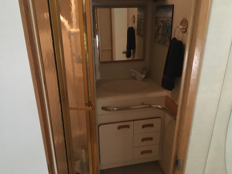 Slide: The Image of Bathroom interior of 1994 Sea Ray 500 Sundancer yacht with mirror and storage cabinets. - 16
