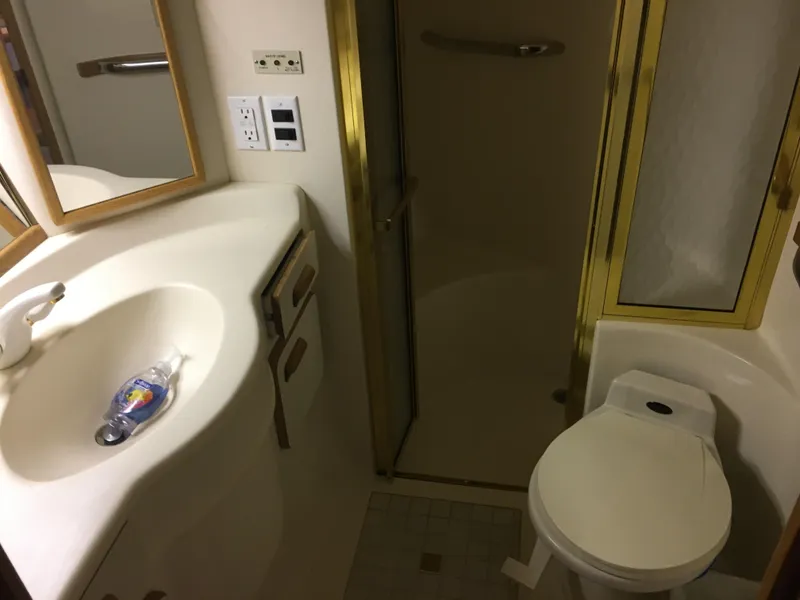 Slide: The Image of Bathroom interior of 1994 Sea Ray 500 Sundancer yacht, featuring sink, toilet, and shower. - 18
