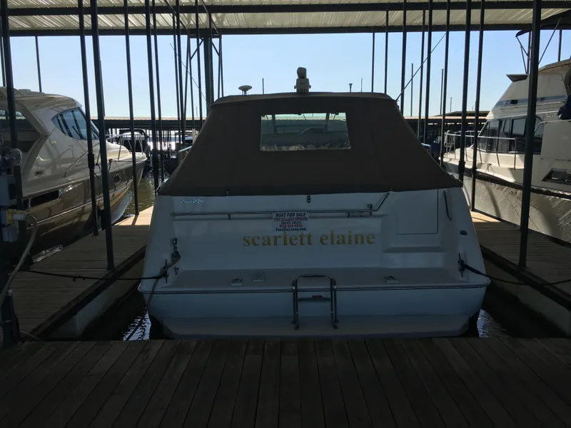 Slide: The Image of 1994 Sea Ray 500 Sundancer docked, rear view with canopy, named "Scarlett Elaine." - 2