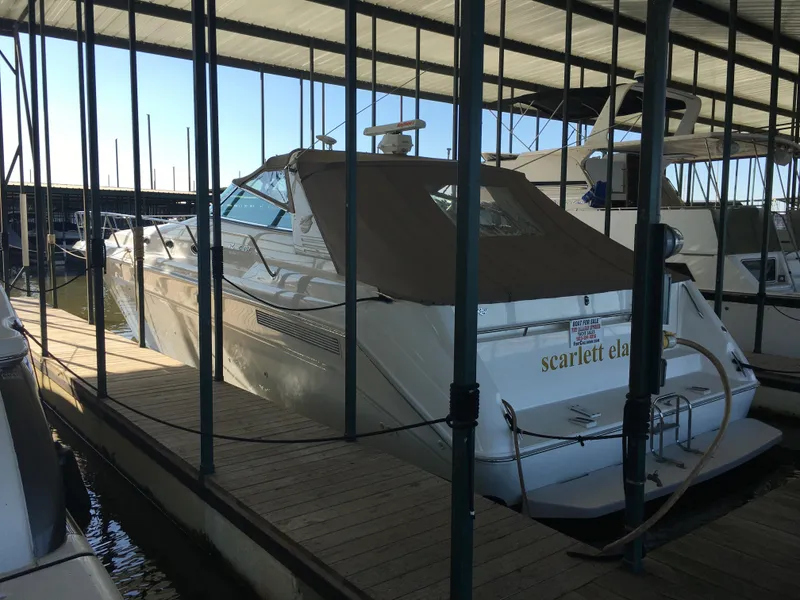 Slide: The Image of 1994 Sea Ray 500 Sundancer docked in a marina under a covered slip. - 3