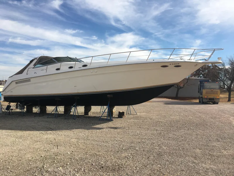 Slide: The Image of 1994 Sea Ray 500 Sundancer yacht on stands, under a partly cloudy sky. - 5