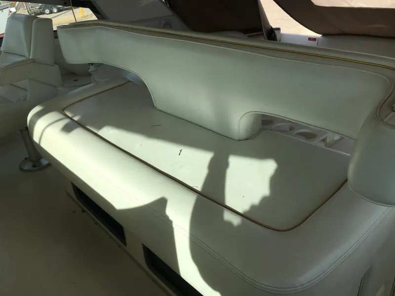 Slide: The Image of 1994 Sea Ray 500 Sundancer interior seating with white upholstery and shadow. - 6